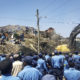 Police officers secure the perimeter at the scene of a garbage landslide, as excavators aid rescue efforts, on the outskirts of the capital Addis Ababa, Ethiopia Sunday, March 12, 2017. Officials and residents say more than a dozen people have been killed in a landslide at a massive garbage dump on the outskirts of Ethiopia's capital, and several dozen people are missing. (Photo Elias Meseret | AP )